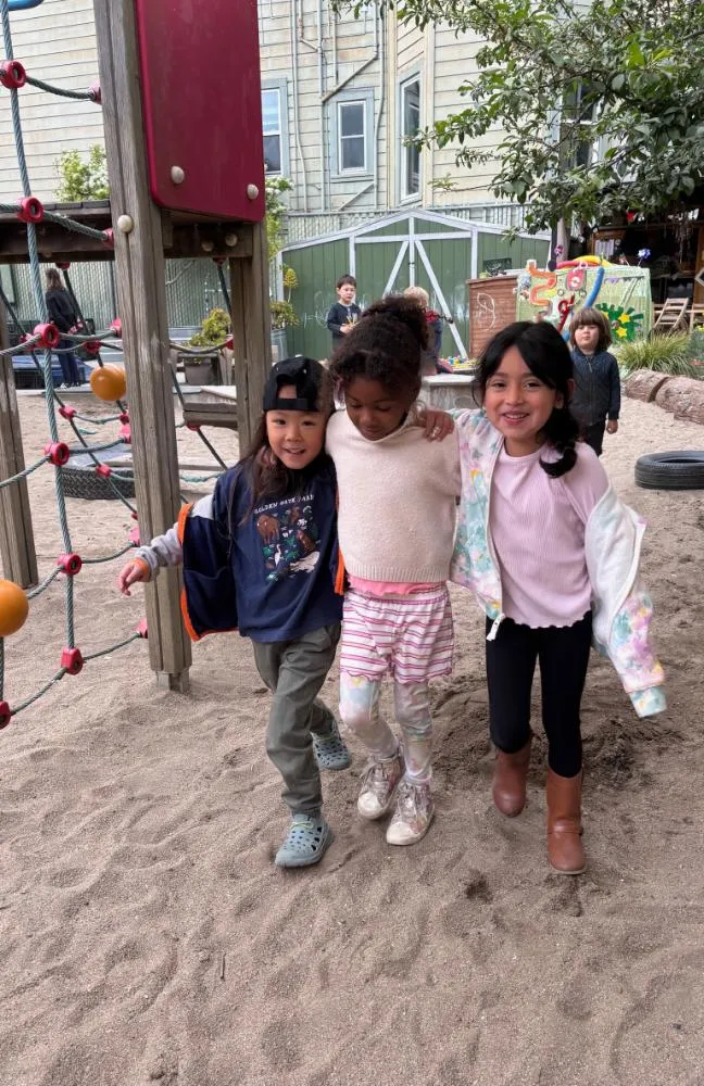 Three young friends with their arms around each other