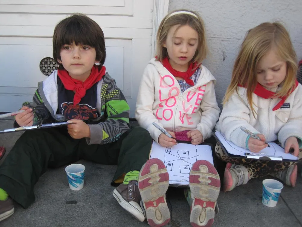 Children drawing on clipboards outside