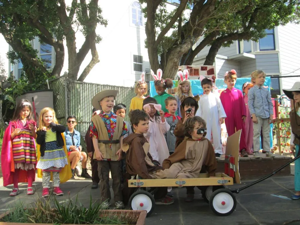 Children in costumes with a wagon at a school celebration