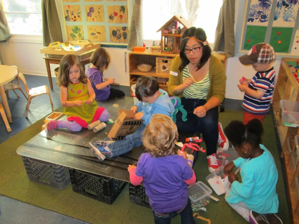 A teacher and children exploring together in the classroom